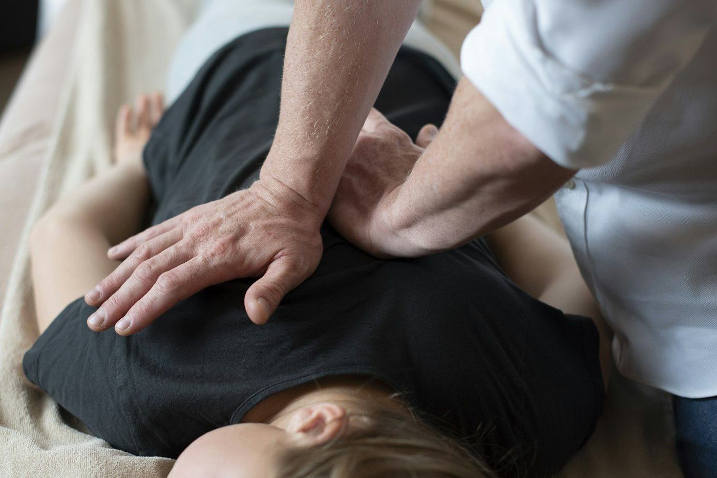 Chiropractor applying pressure to a patient's mid-back