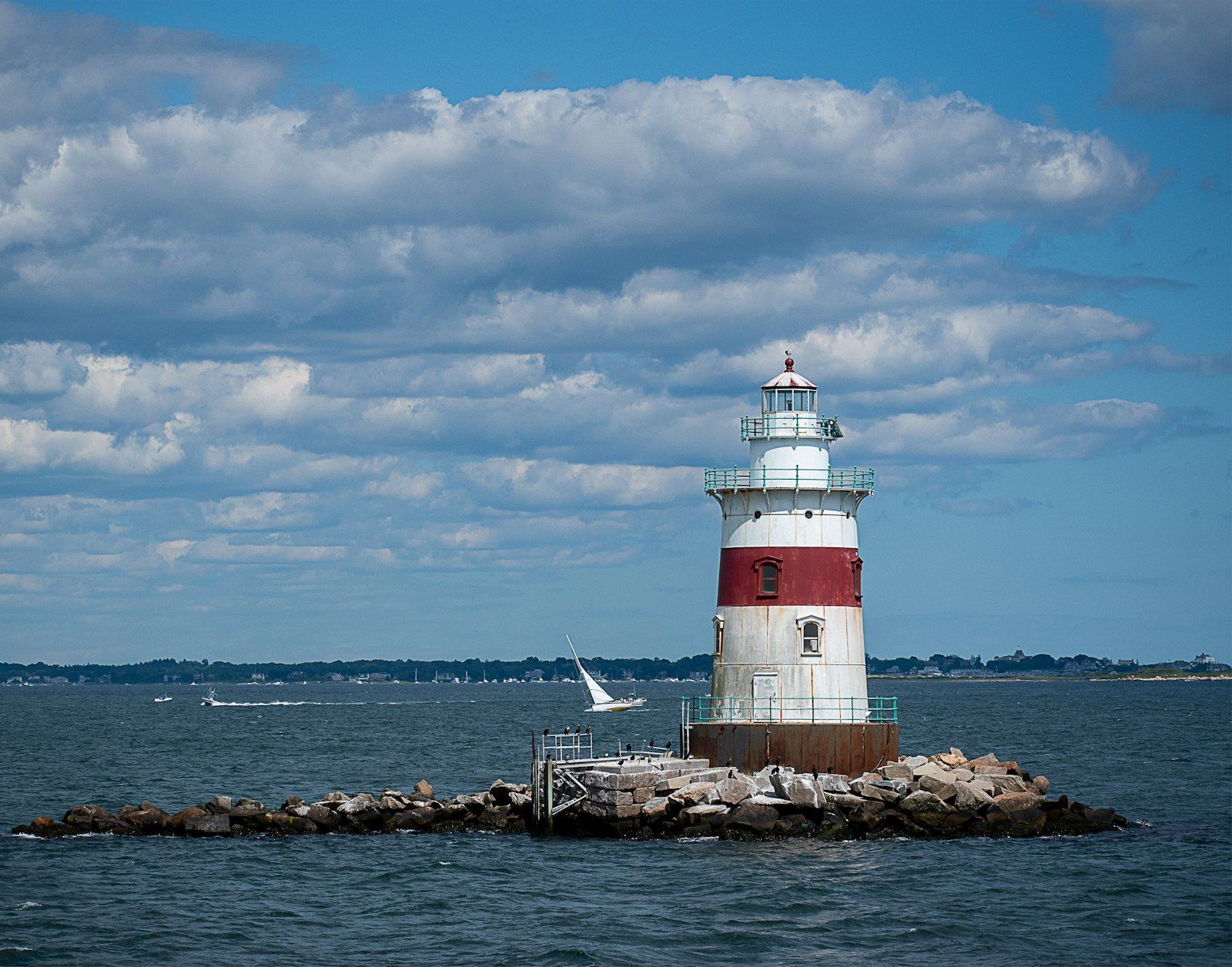 Red and white lighthouse on a Rhode Island pier